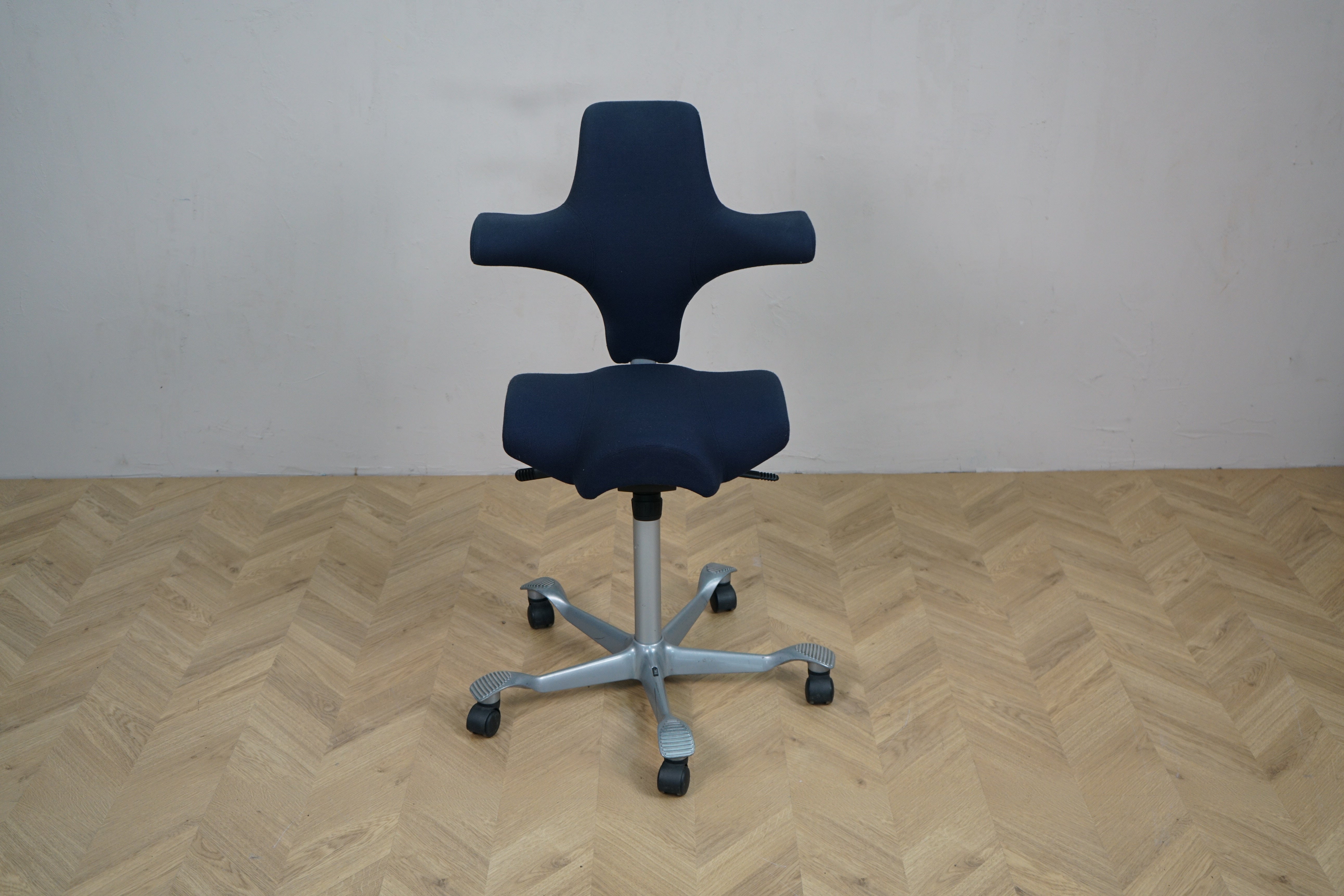 HÅG Capisco 8106 kontorstol i mørkeblå Fame set forfra med sølv aluminiumsfodkryds.